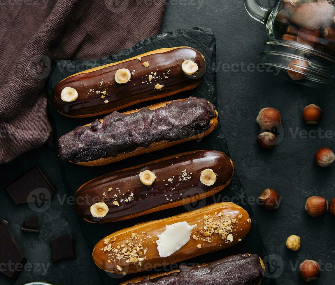 dolce cioccolato eclairs su nero di legno tavola foto