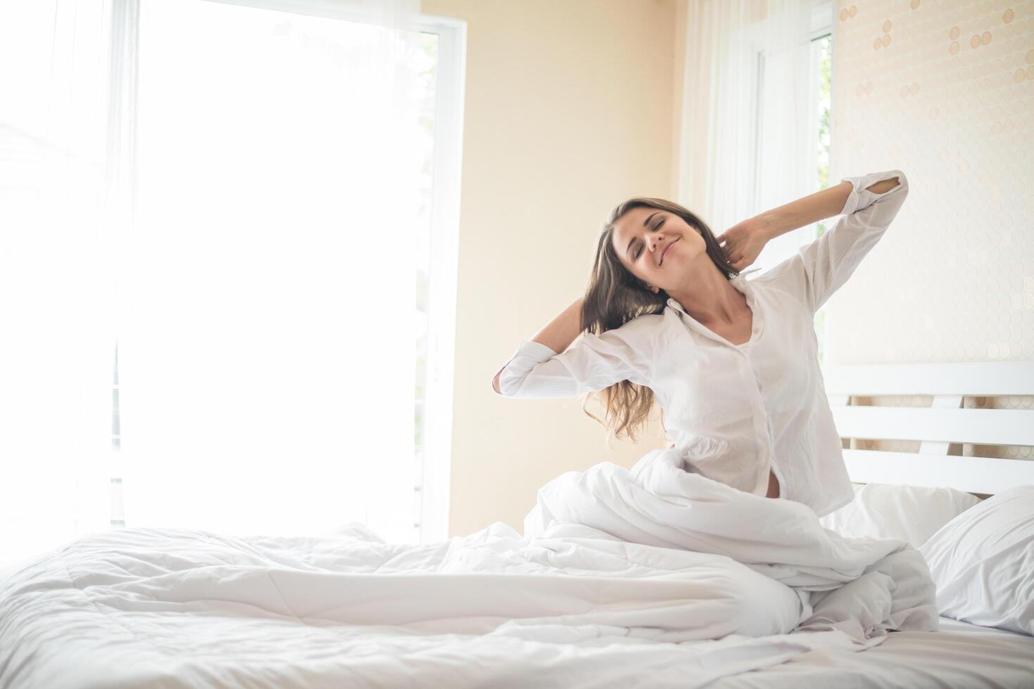 pigra giovane donna seduta in camera da letto foto