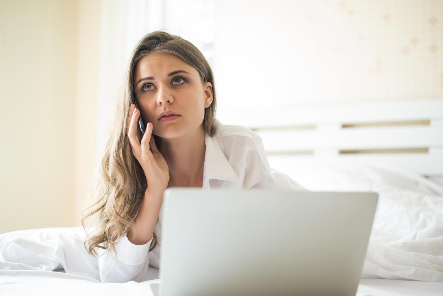 bella donna felice che lavora su un laptop sul letto in casa foto