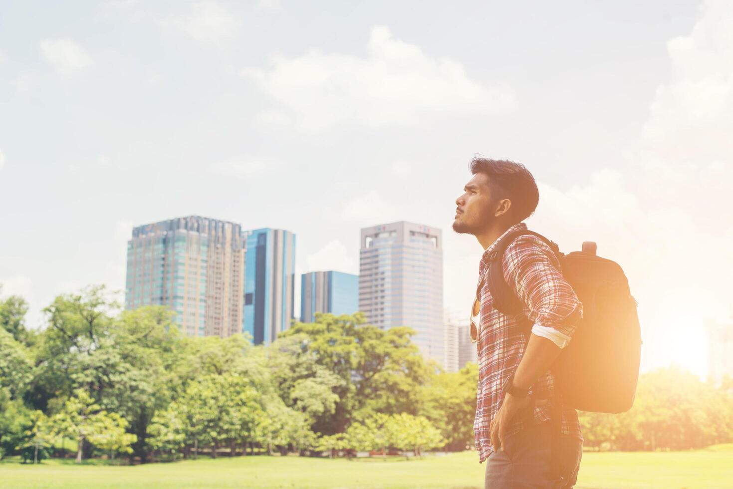 il giovane hipster si gode la vista della città dal parco durante il viaggio foto