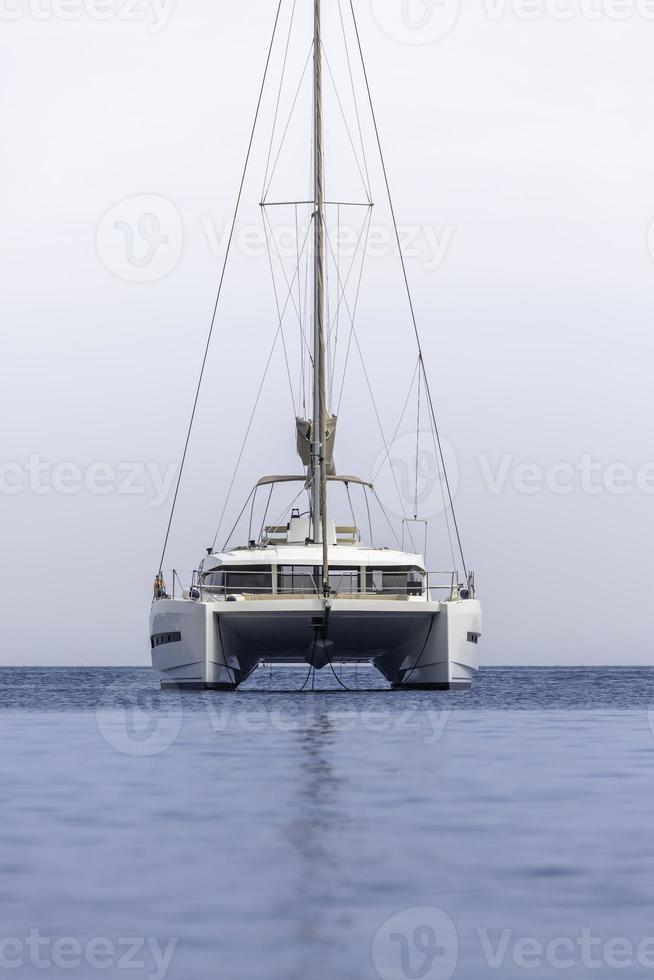 catamarano bianco della barca a vela sull'oceano vicino alla spiaggia. foto