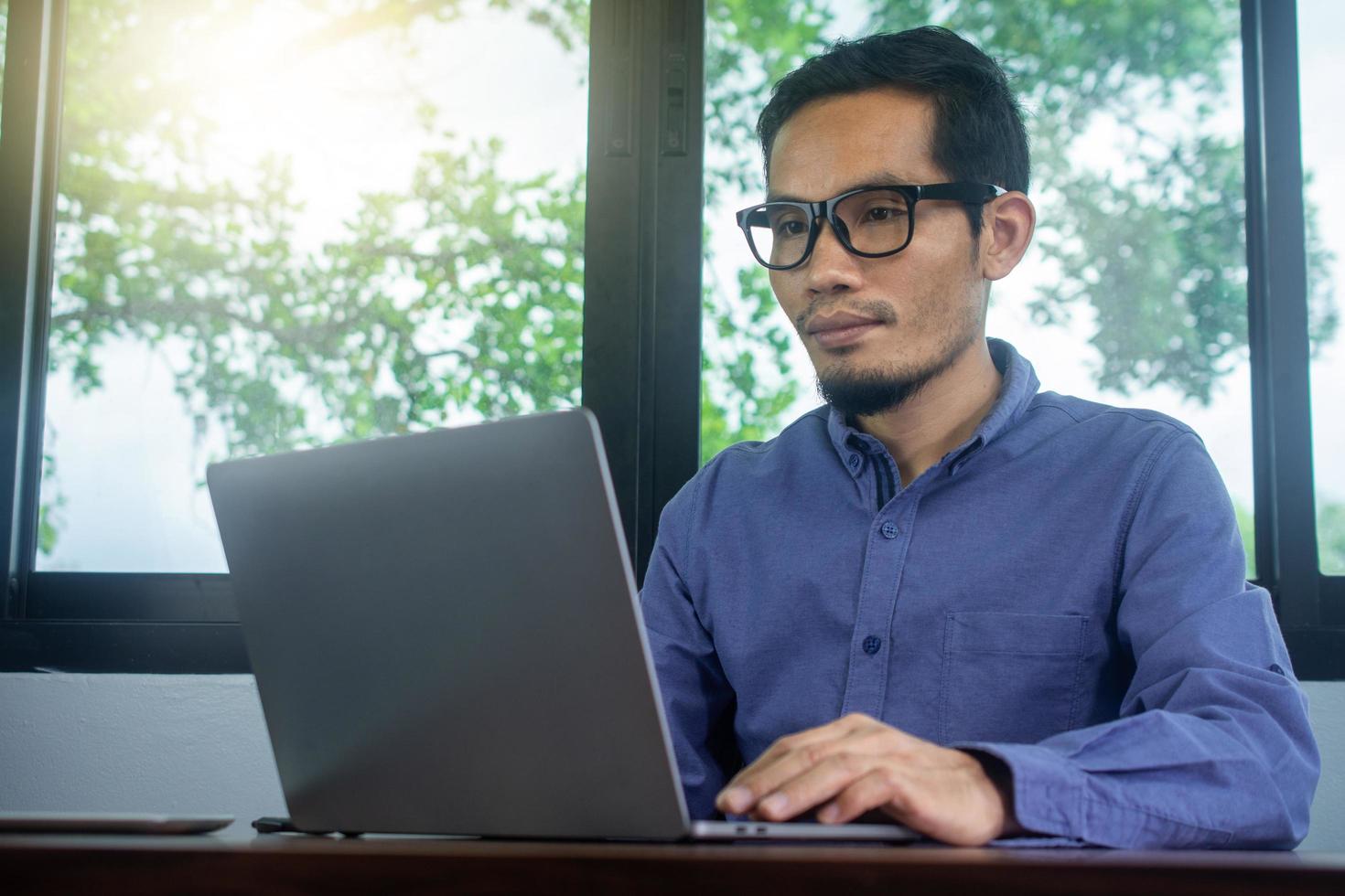 uomo che usa il computer lavora a casa foto