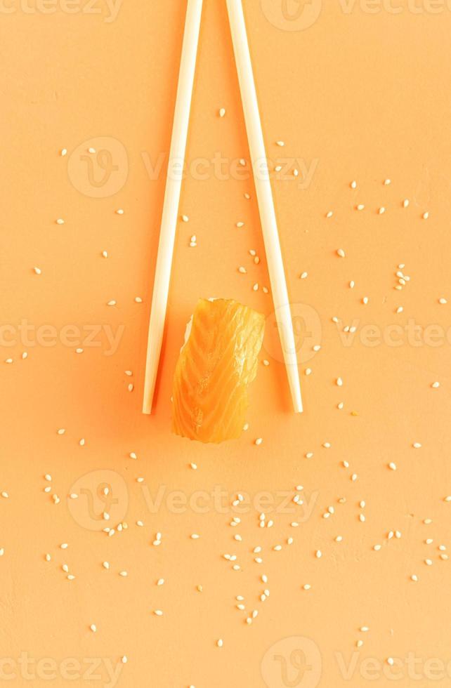 sushi con salmone e bacchette isolate su sfondo arancione foto