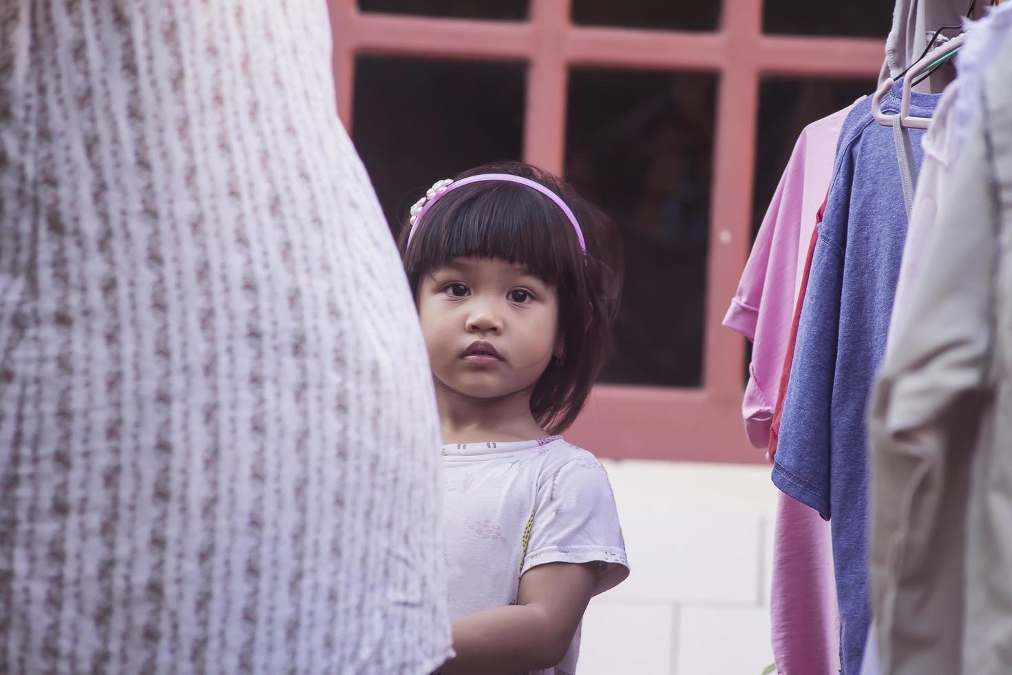 una bambina accompagna sua madre ad asciugare i panni. foto