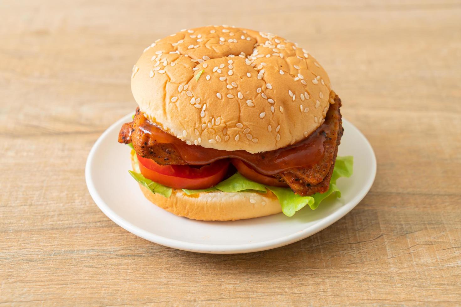 hamburger di pollo alla griglia con salsa su piatto bianco foto