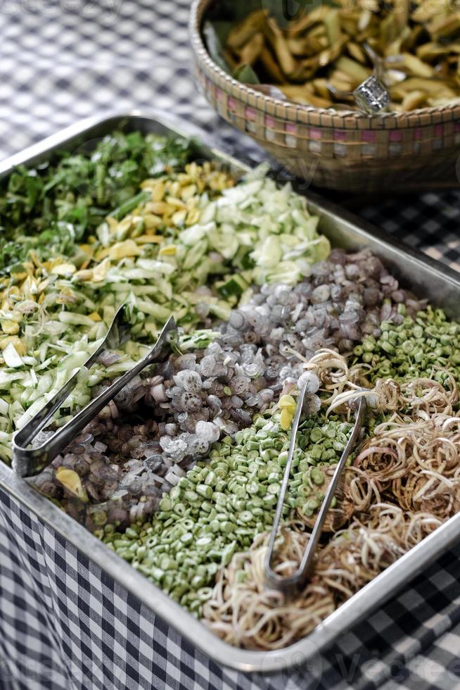 Verdure miste cambogiane sul tavolo del buffet del ristorante tradizionale a Siem Reap con fiori di banana sminuzzati in primo piano foto