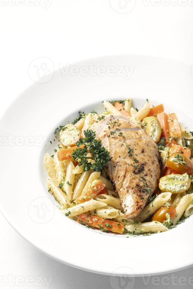 petto di pollo fritto con penne e verdure saltate piatto di pasta su sfondo bianco foto