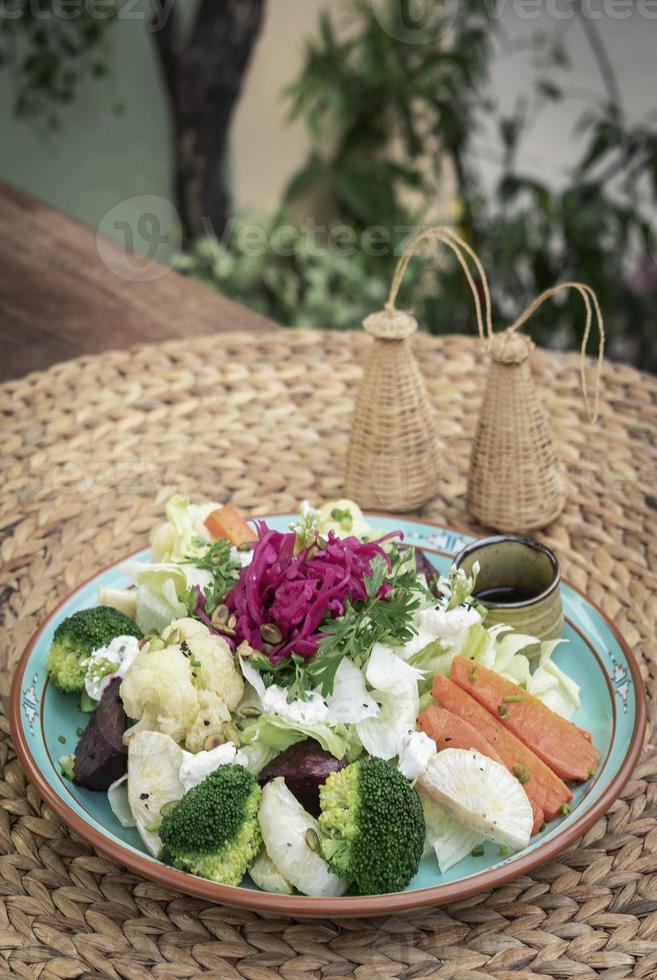 insalata rustica di cottage con sane verdure miste al vapore e fresche su piatto colorato all'aperto in giardino foto