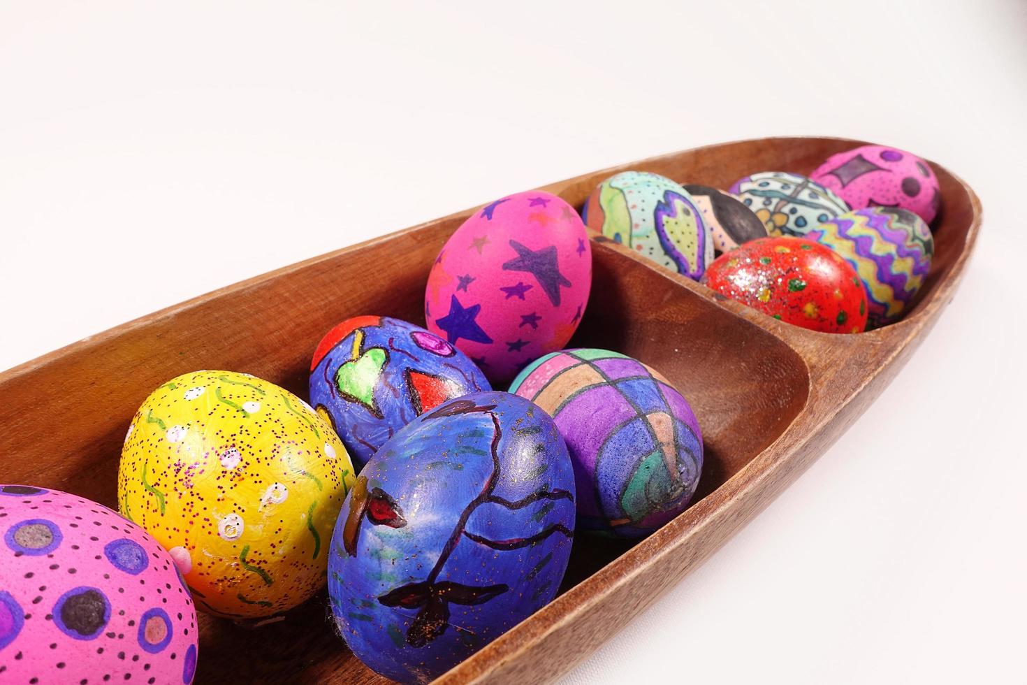 pasquali colorate uova di pasqua in un piatto di legno foto