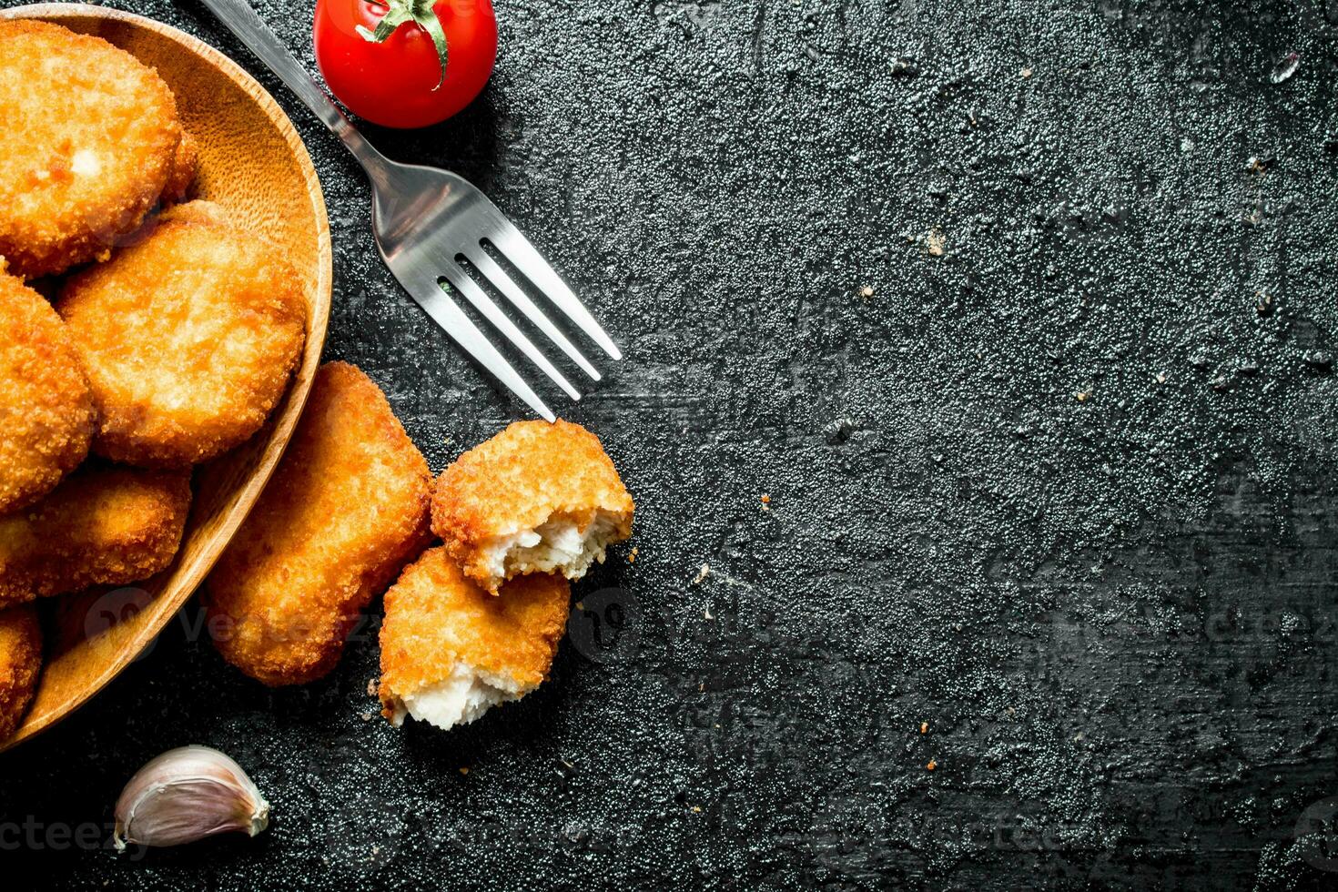 pollo pepite con un' fetta di aglio e pomodoro. foto