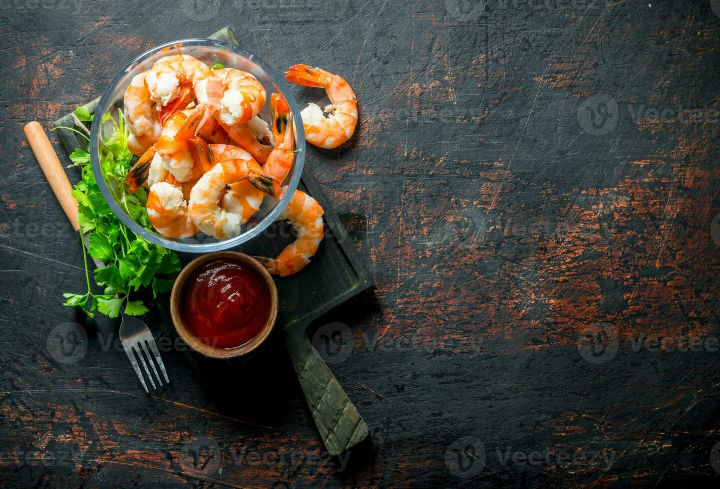 gamberetti nel un' ciotola su un' taglio tavola con prezzemolo e pomodoro salsa. foto