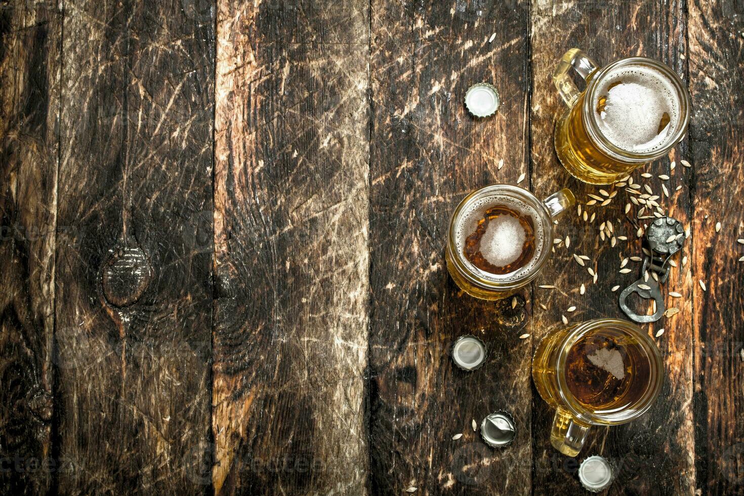 fresco birra nel un' bicchiere con tappi e un' bottiglia apriscatole. foto