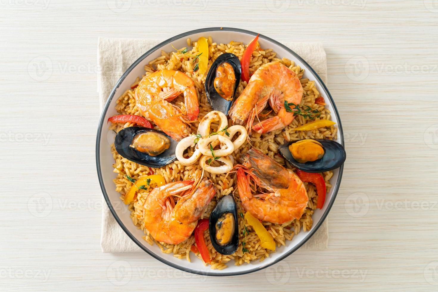 paella di mare con gamberi, vongole, cozze su riso allo zafferano foto