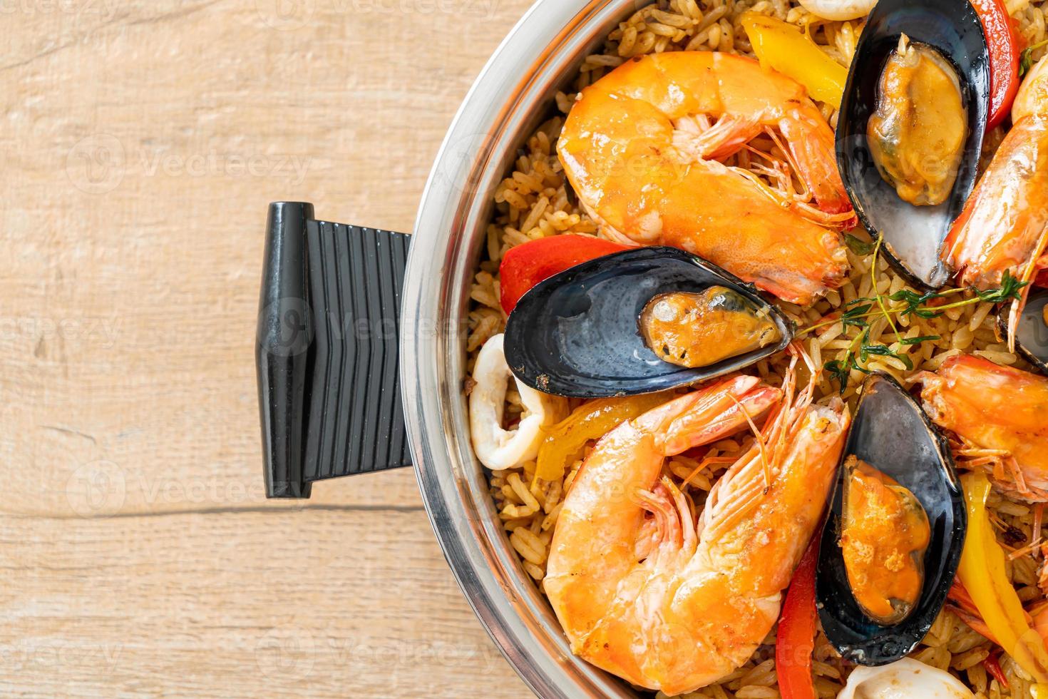 paella di mare con gamberi, vongole, cozze su riso allo zafferano foto