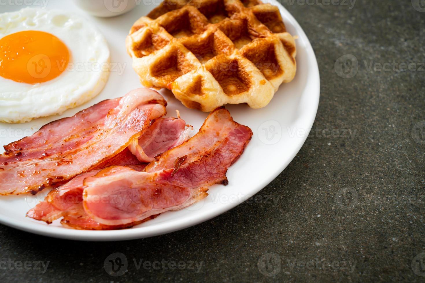 uovo fritto con bacon e waffle per colazione foto