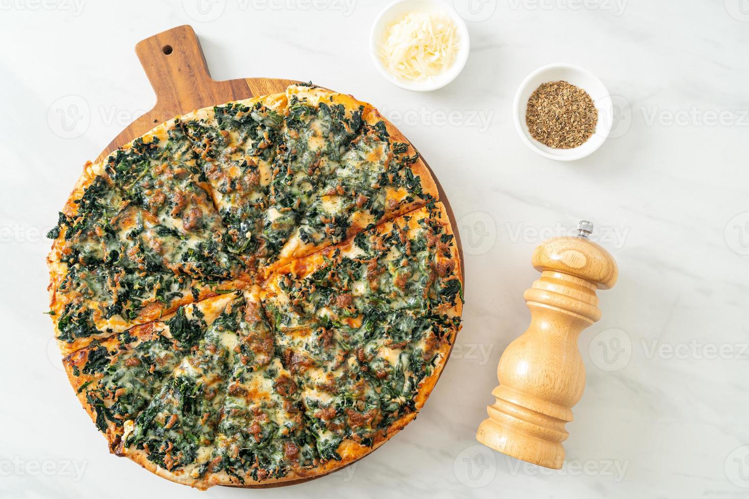 pizza spinaci e formaggio su vassoio in legno - stile vegano e vegetariano foto