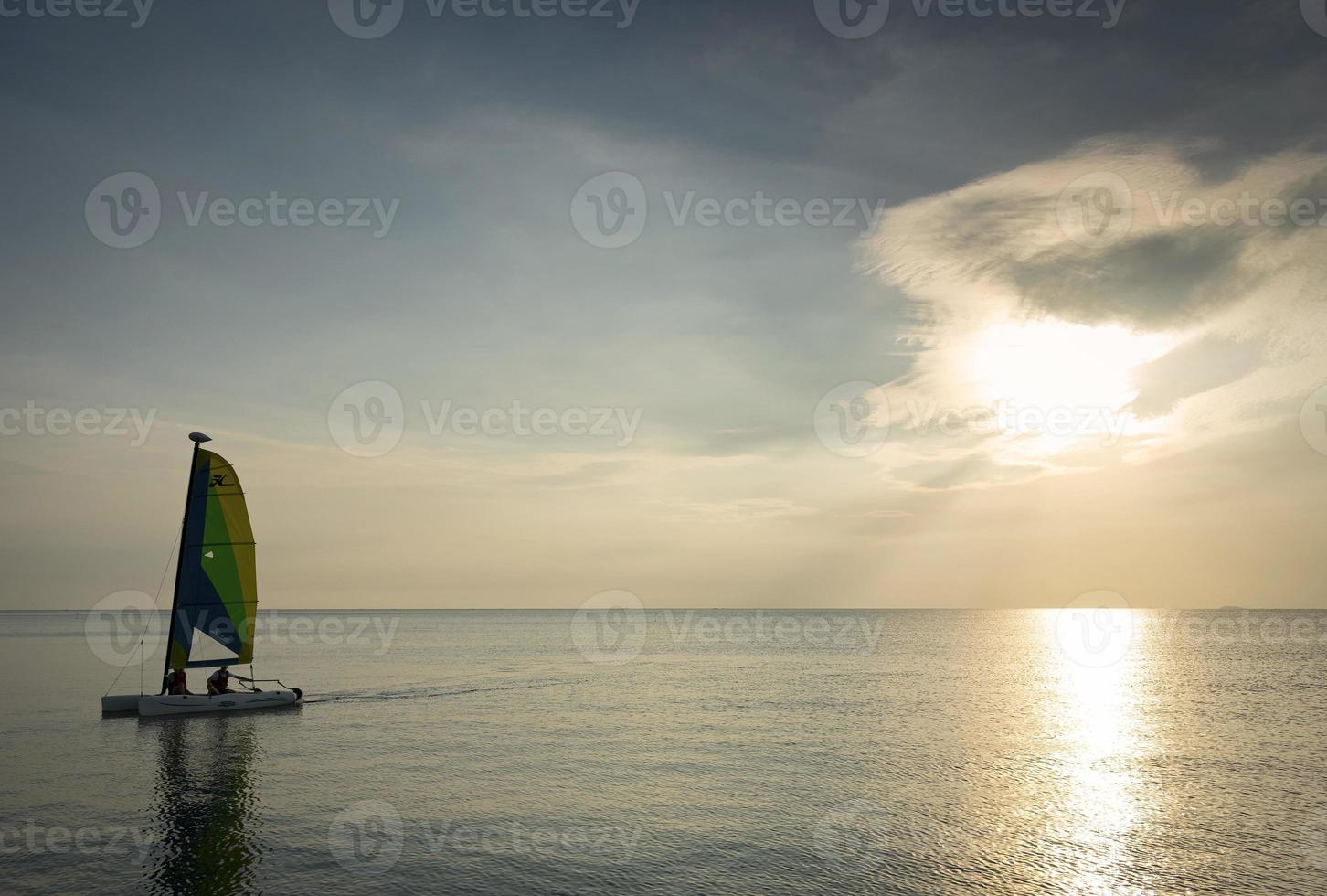 barca a vela in mare durante il tramonto nella costa di phuket in thailandia foto