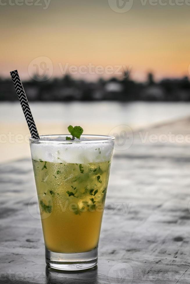 Cocktail misto mojito al frutto della passione con schiuma di albume d'uovo piccante nel bar lungo il fiume di Vientiane, Laos foto