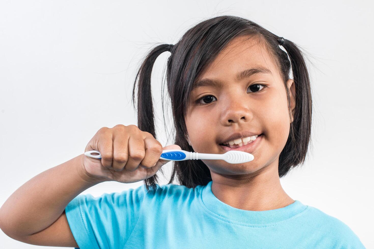 bambina che si lava i denti in studio shot foto