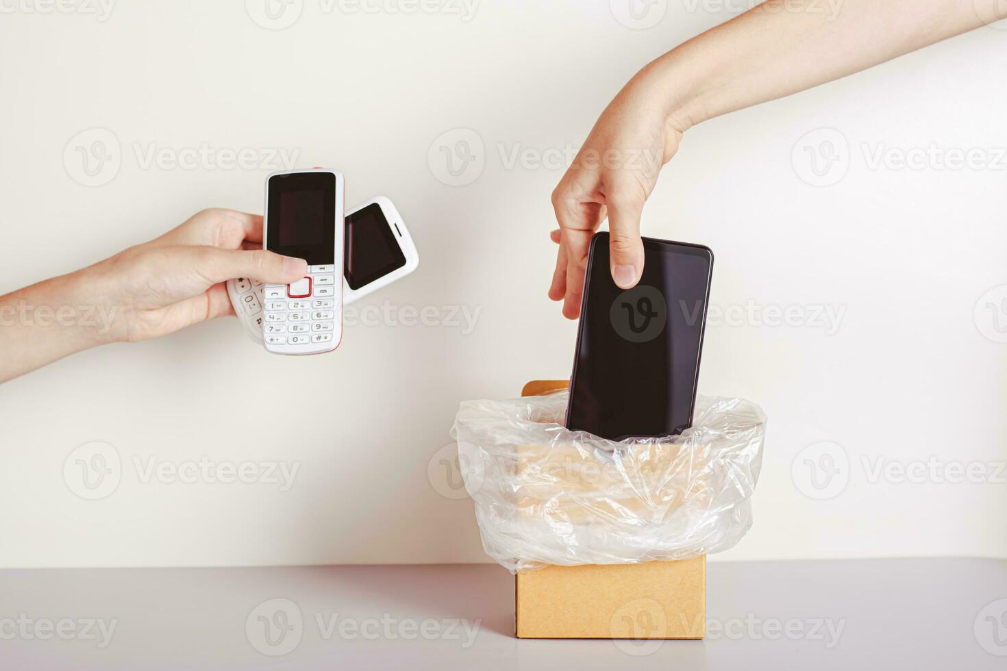 il mano lanci il smartphone in il spazzatura e il secondo mano detiene premi il bottone telefoni foto