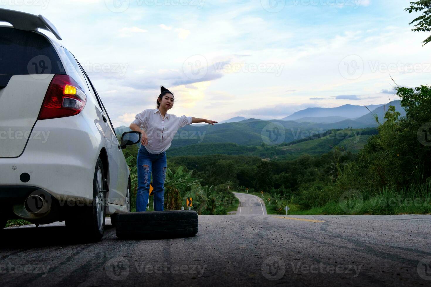 donna che fa l'autostop sulla strada sulla strada pubblica nella zona della foresta foto