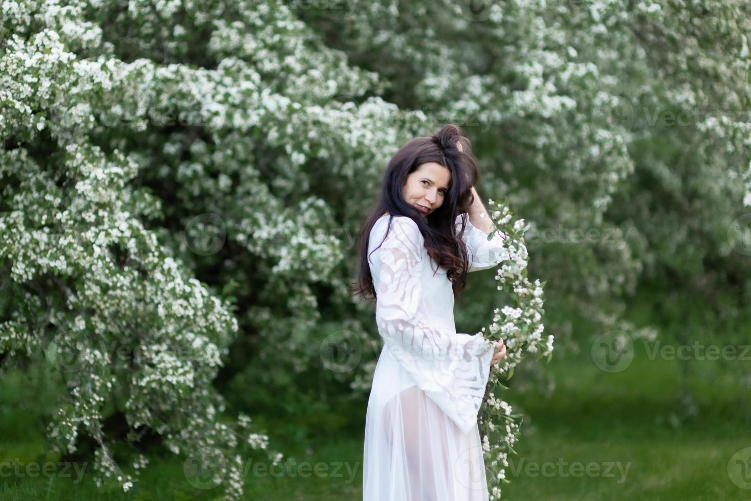 ritratto di giovane donna nel parco tra i rami fioriti foto