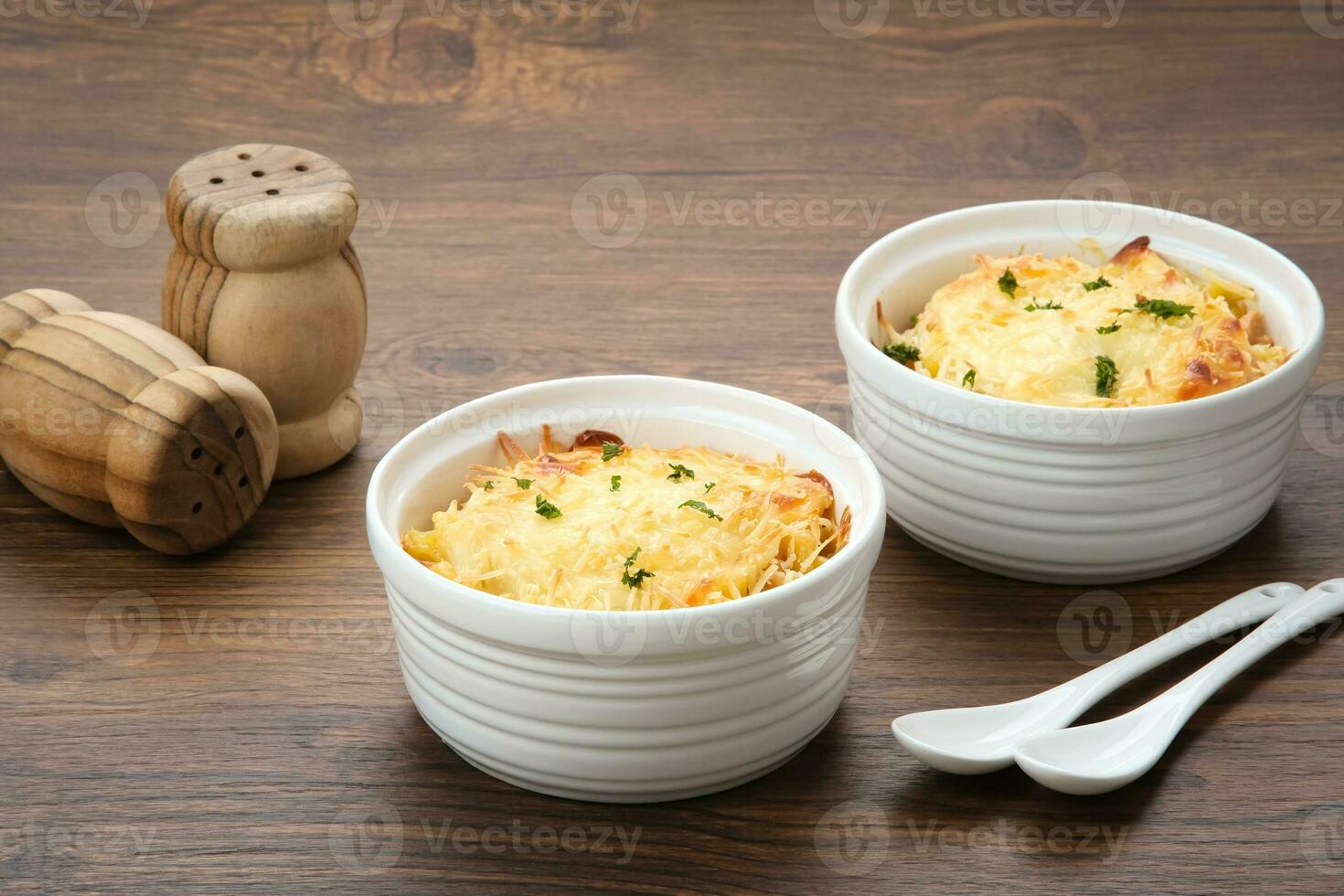 al forno maccheroni e formaggio su un' bianca ciotola con parmigiano e erbe aromatiche foto