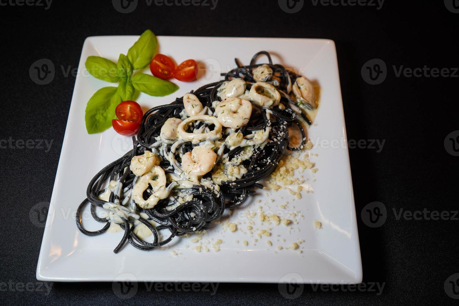 spaghetti rigate - pasta nera con frutti di mare misti foto
