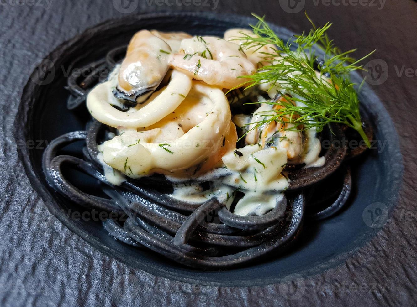 spaghetti rigate - pasta nera con frutti di mare misti foto