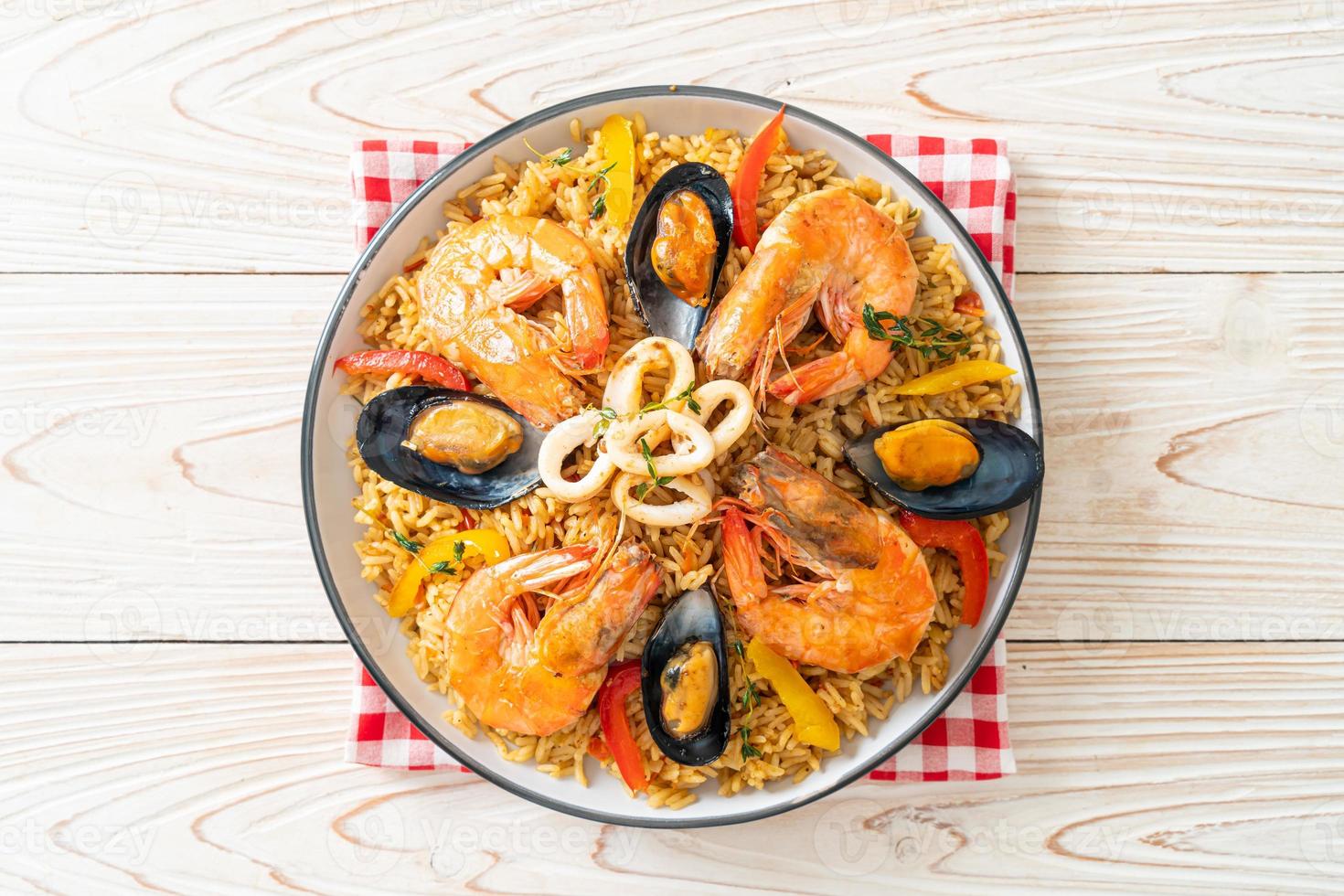 paella di mare con gamberi, vongole, cozze su riso allo zafferano foto