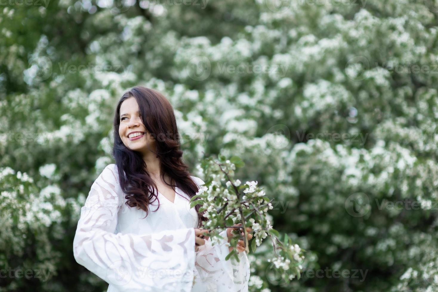 ritratto di giovane donna nel parco tra i rami fioriti foto