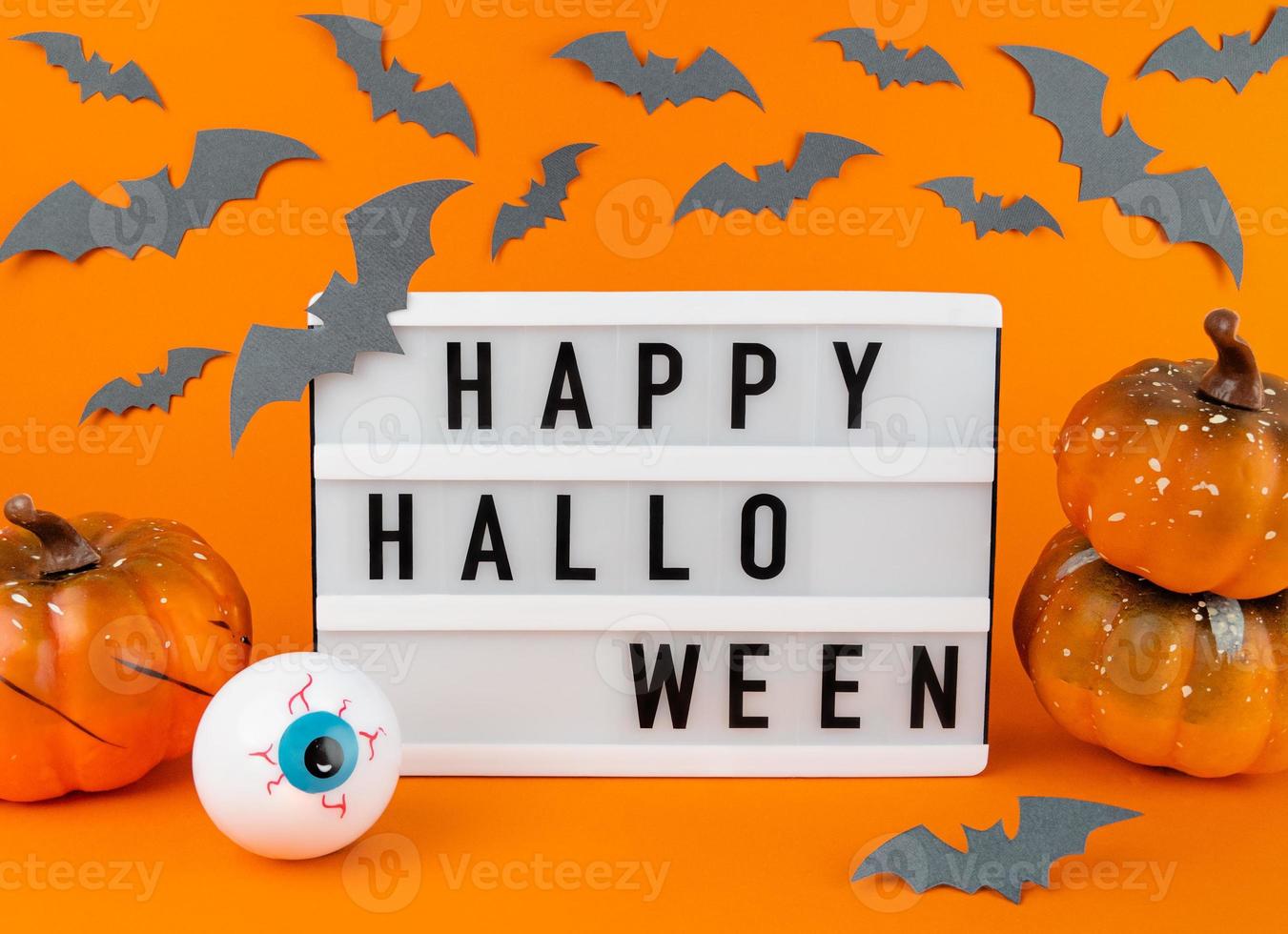 scatola luminosa con frase di halloween felice con zucche, pipistrelli e bulbo oculare foto