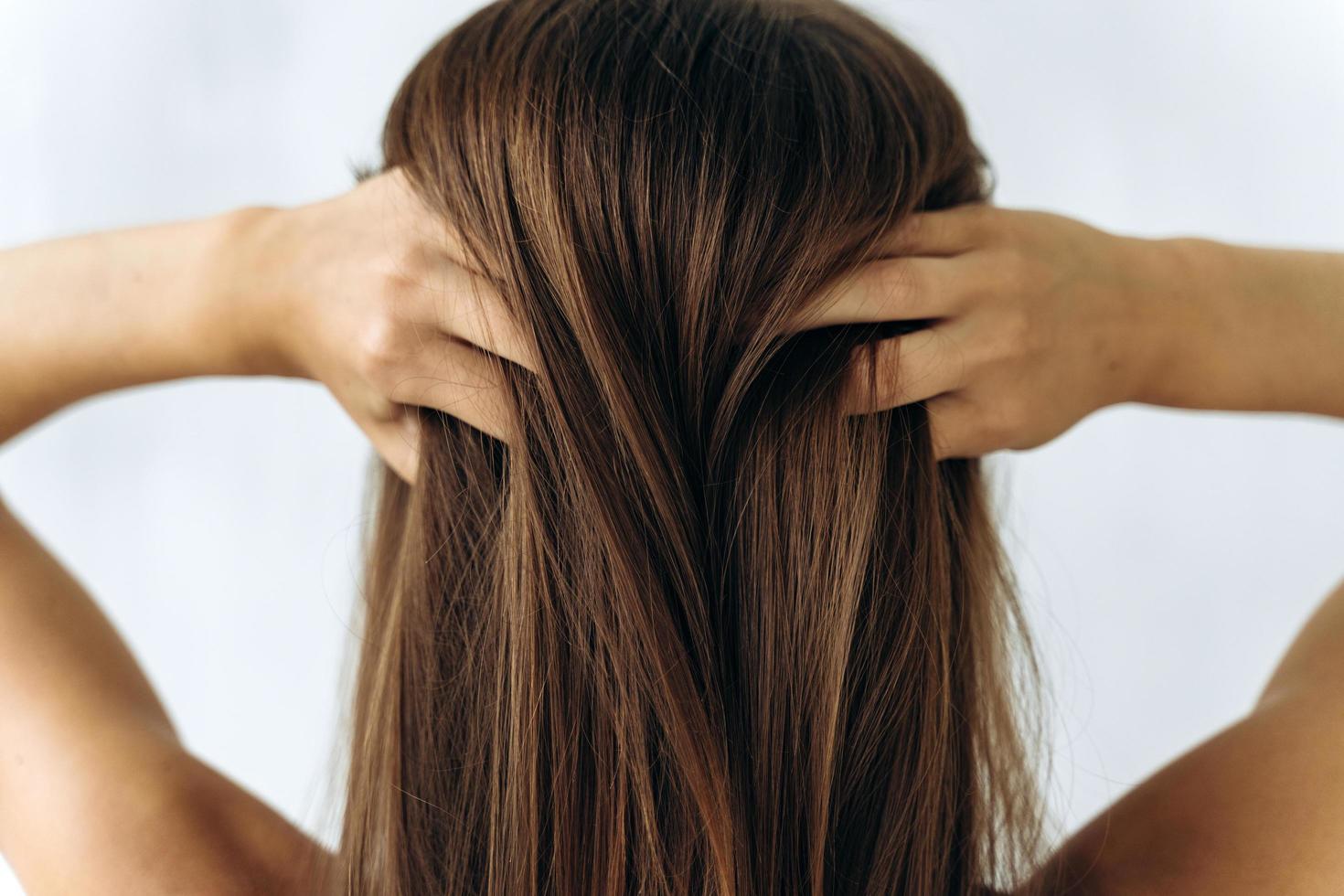 ragazza che si tocca i capelli e passa le dita tra i capelli foto