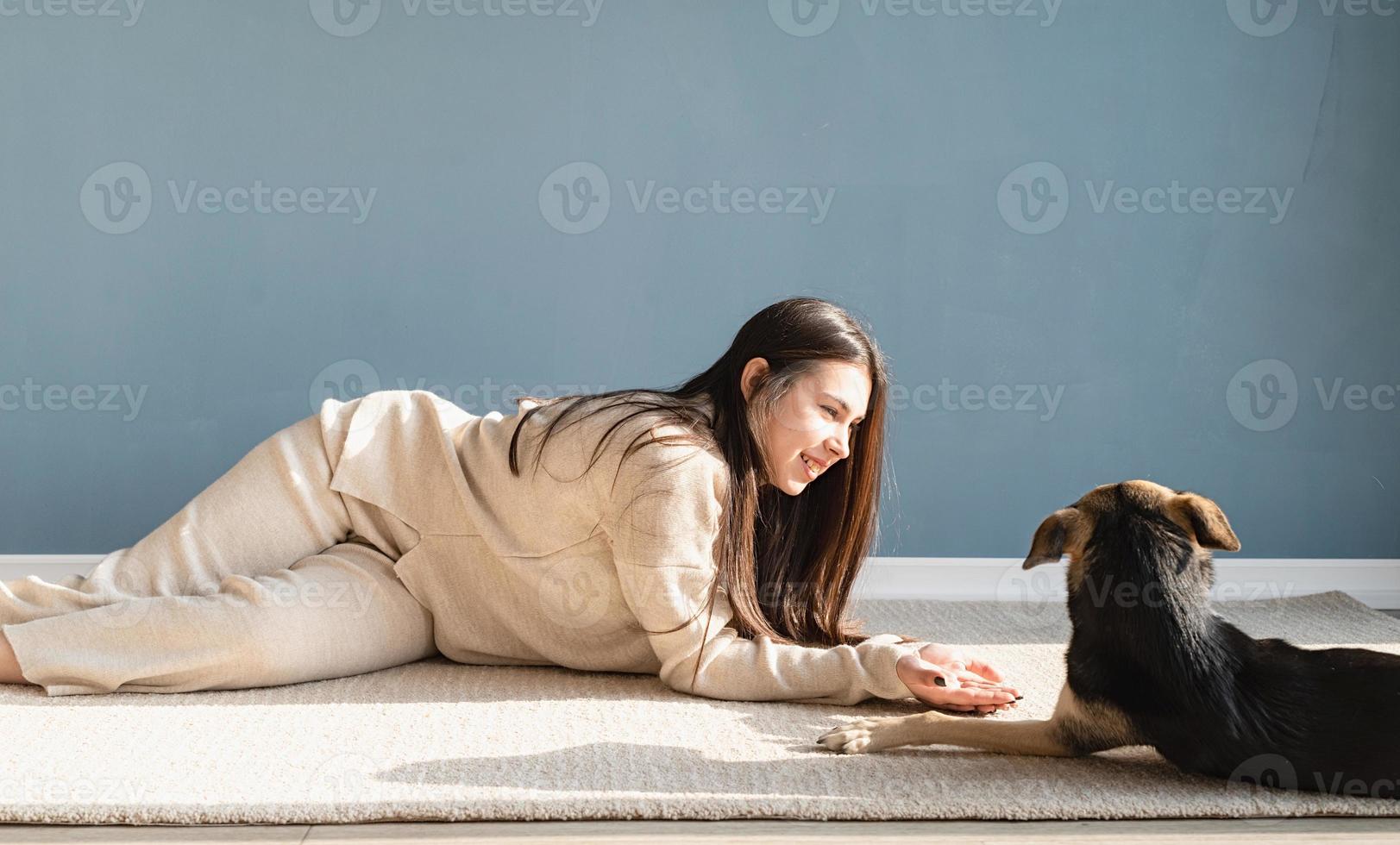 bella donna con cane giocoso che si abbraccia a casa foto
