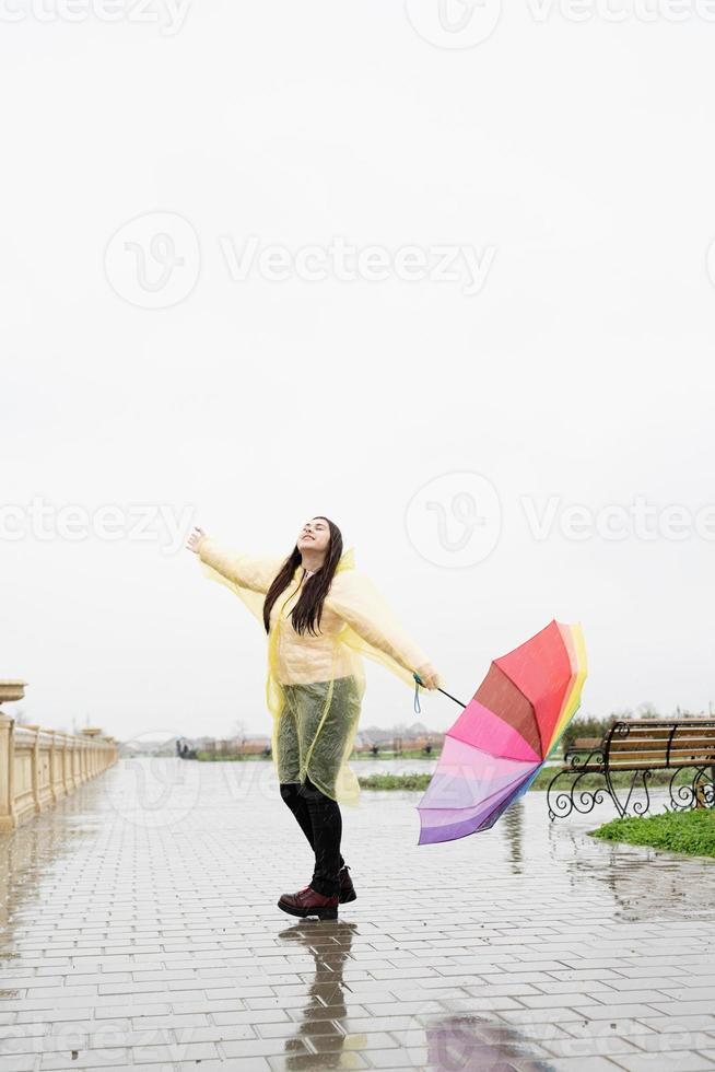 donna che tiene l'ombrello catturando le gocce di pioggia, godendosi la pioggia foto