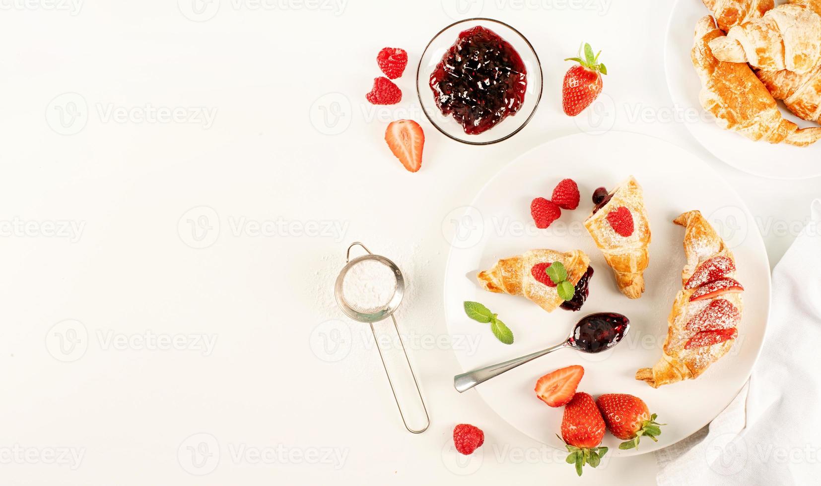 buonissimi croissant dorati ripieni di marmellata di fragole foto