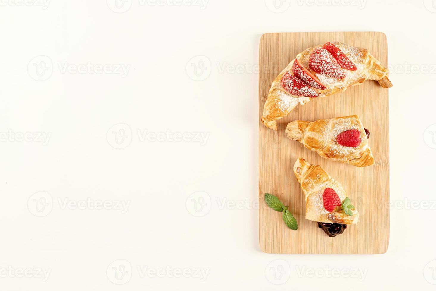 buonissimi croissant dorati ripieni di marmellata di fragole foto