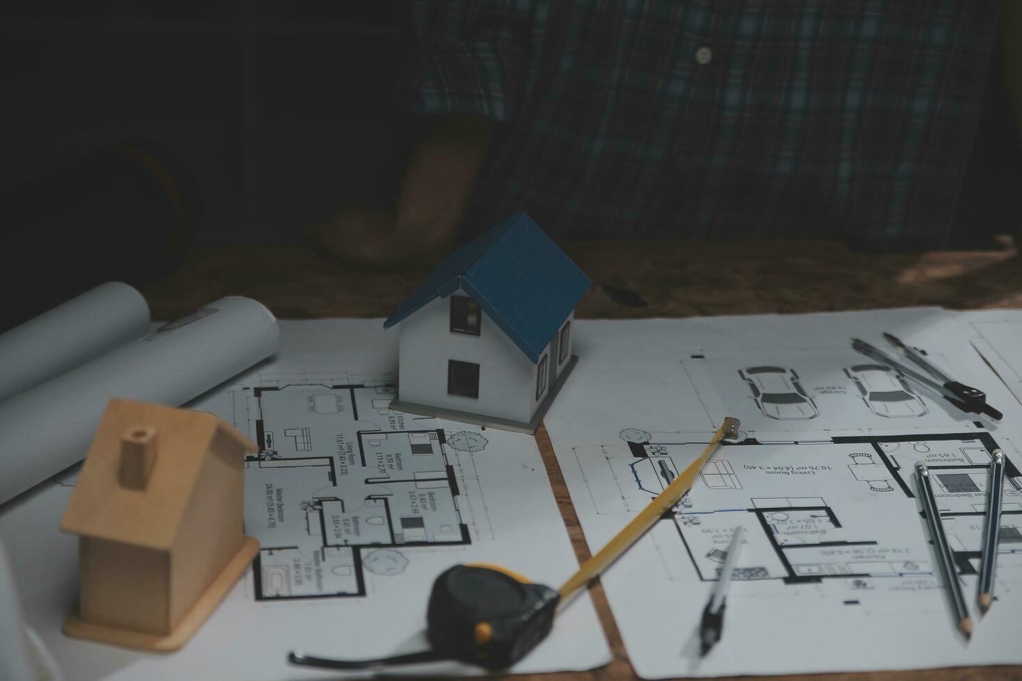 squadra di multietnico architetti Lavorando su costruzione piani nel incontro camera. ingegneri discutere su progetto nel ufficio. maturo uomo d'affari e donna in piedi in giro tavolo Lavorando su planimetria. foto