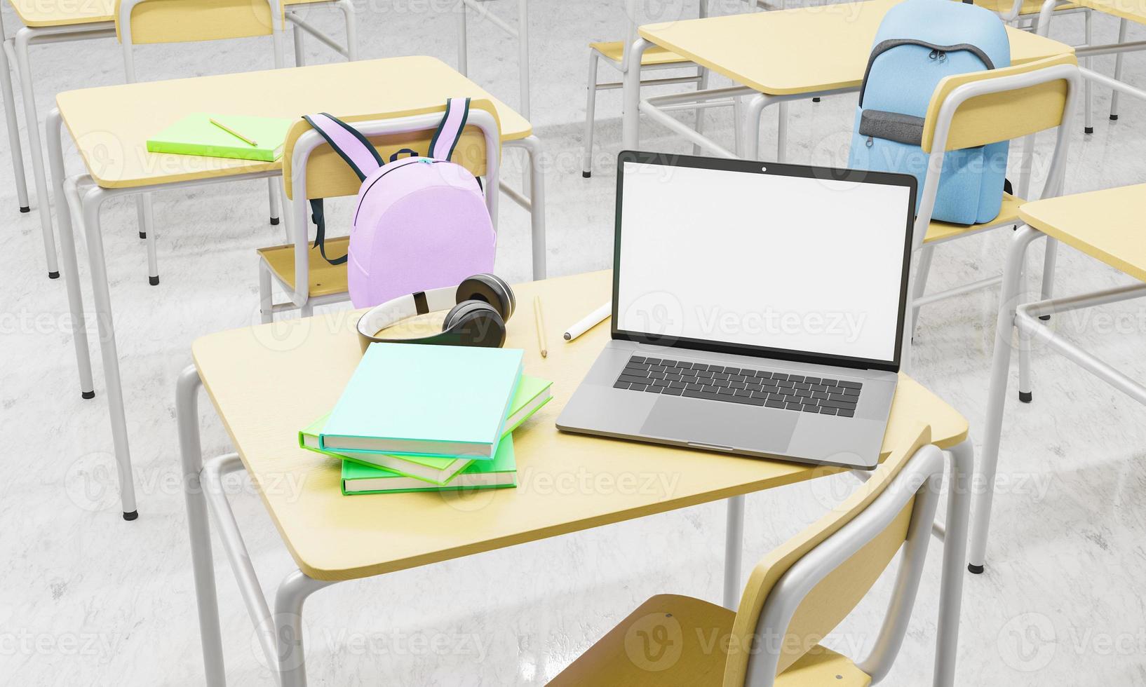 laptop su un banco di scuola in un'aula con libri e forniture in giro foto