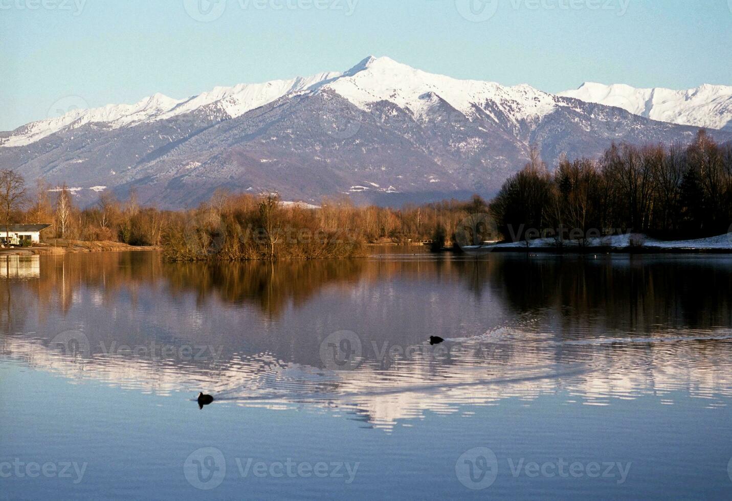 sereno bellezza blu lago nel Savoie con neve capped montagne foto