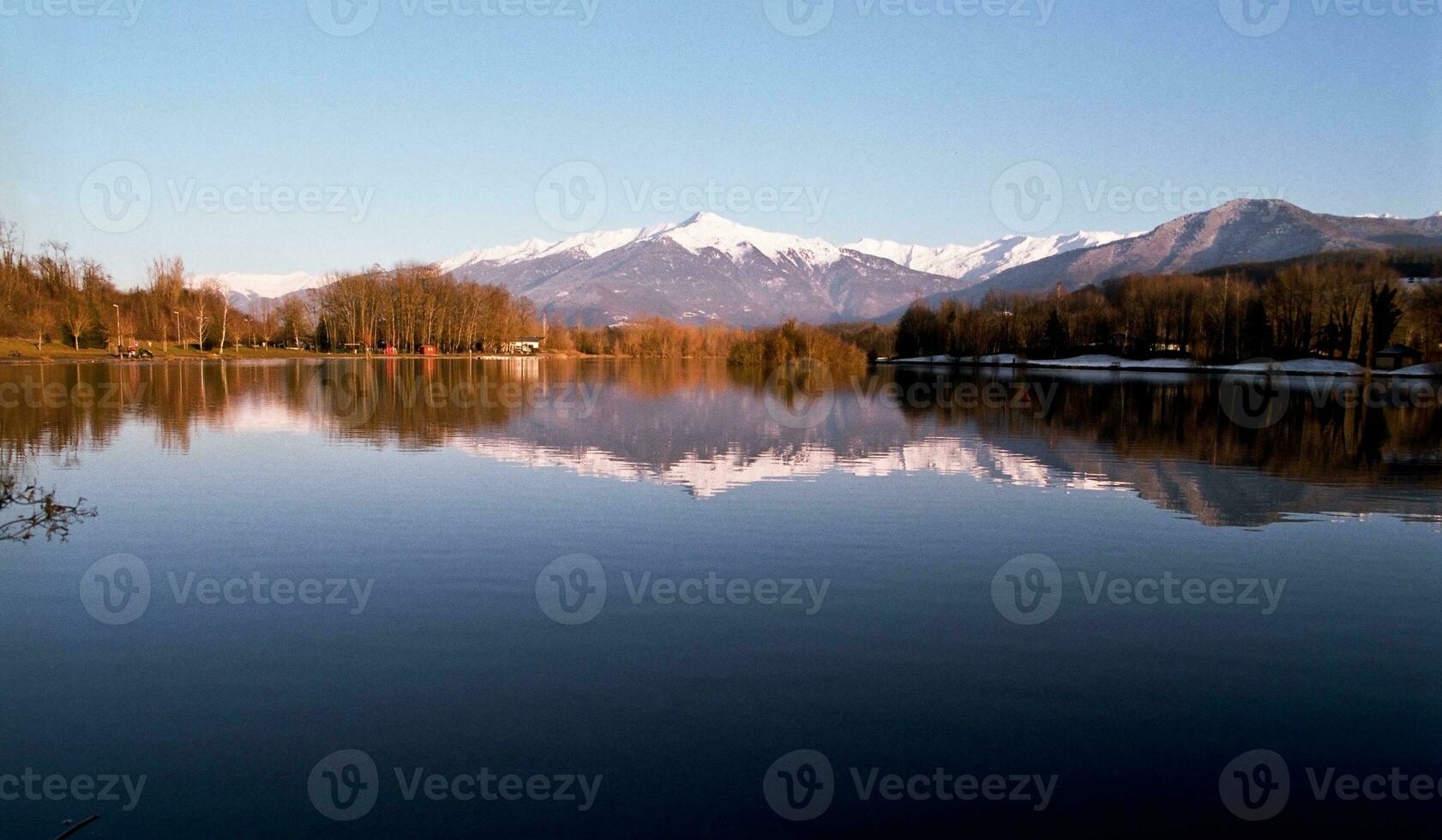 sereno bellezza blu lago nel Savoie con neve capped montagne foto