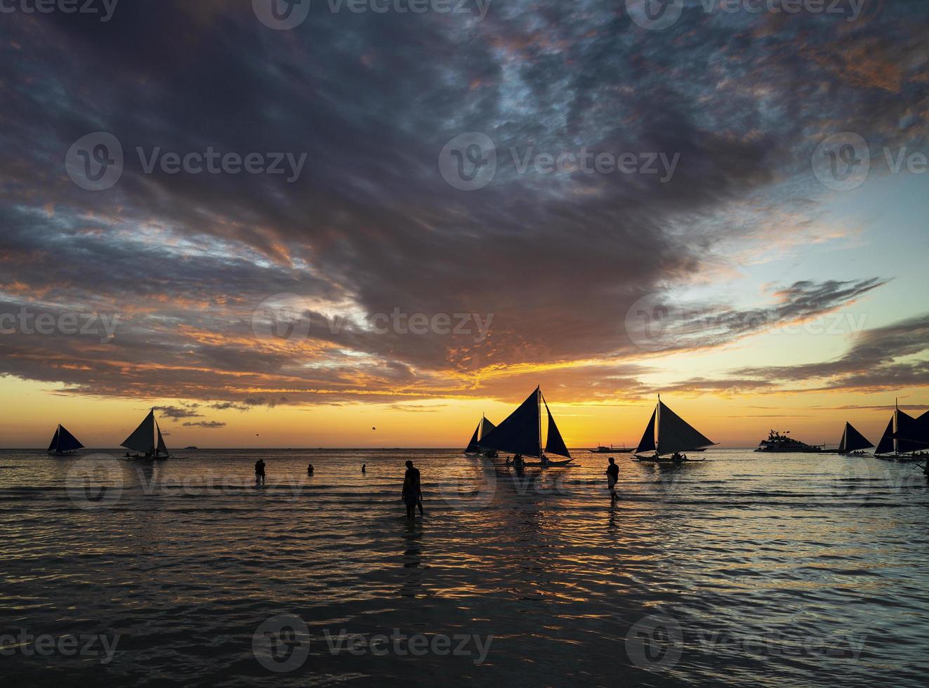 bellissimo tramonto tropicale con barche a vela e turisti nelle Filippine dell'isola di Boracay foto