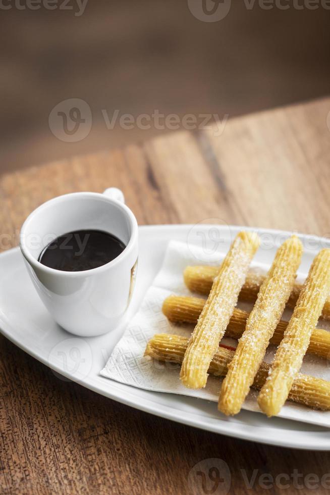 Churros con cioccolato tradizionale colazione dolce spagnola impostata su un tavolo di legno foto