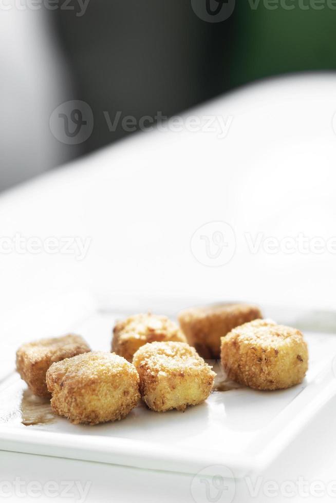 purè di patate fritte crocchette quadrate semplice contorno vegetariano su piatto bianco foto