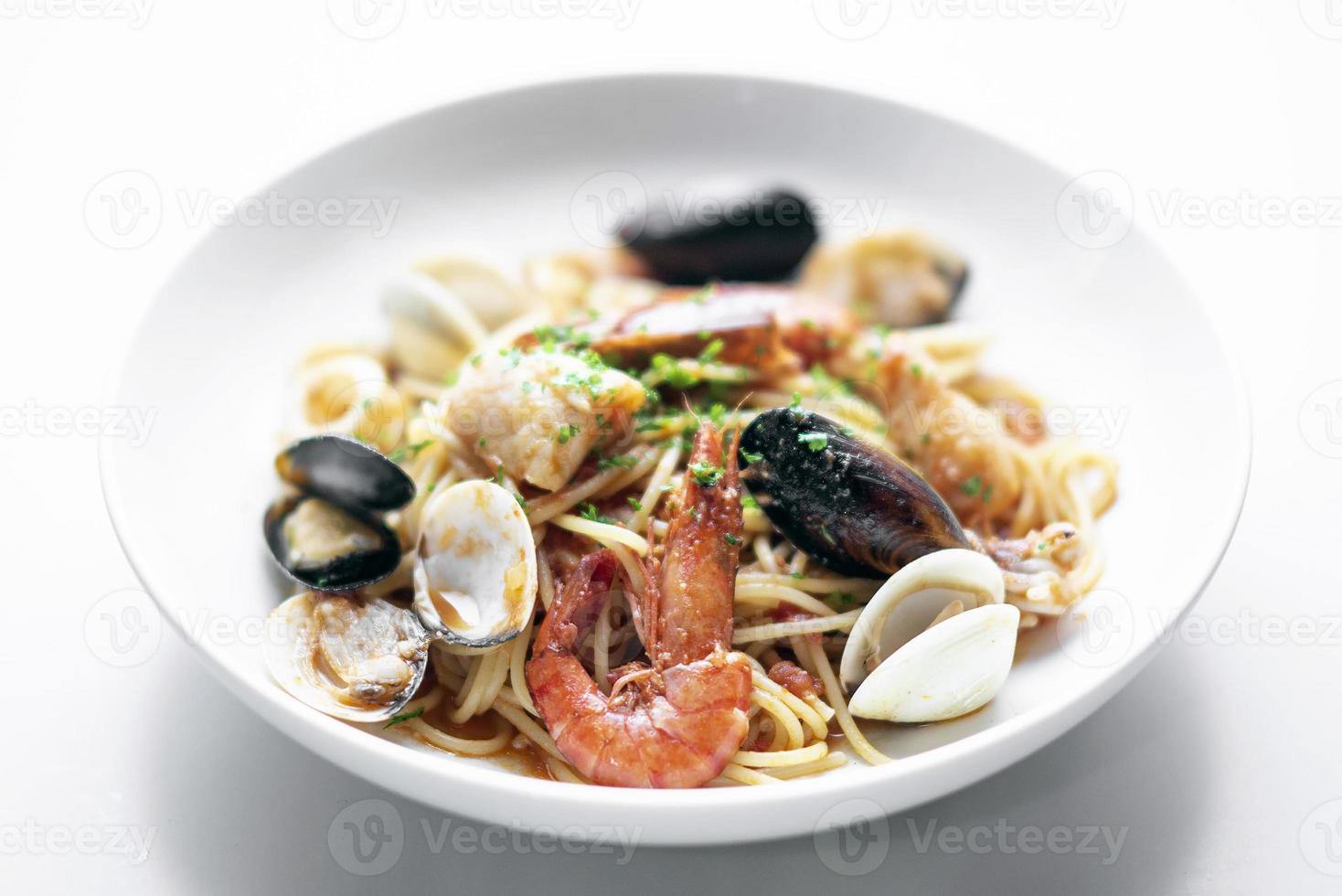 spaghetti misti di pesce fresco italiano con gamberi cozze capesante e vongole veraci foto