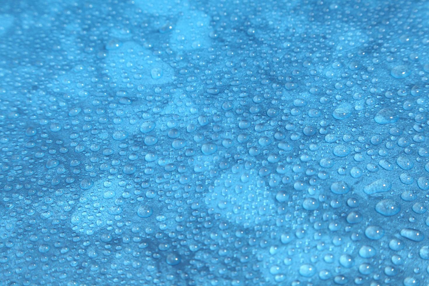 primo piano gocce d'acqua su sfondo blu foto