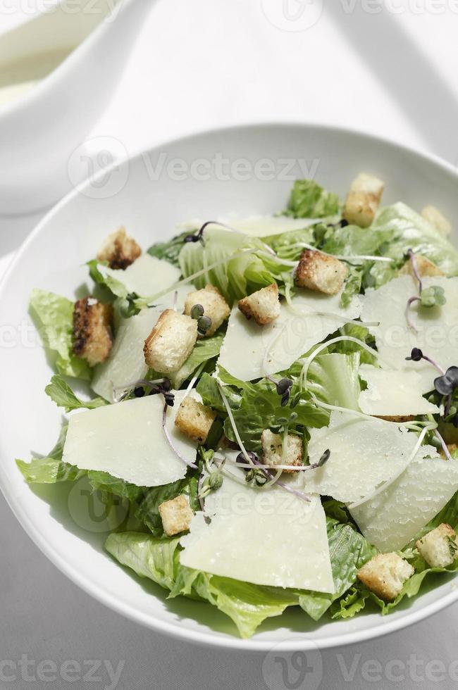 caesar salad con parmigiano e crostini su tavola di legno foto