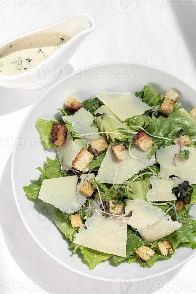 caesar salad con parmigiano e crostini su tavola di legno foto