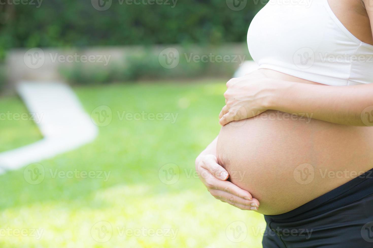 incinta asiatica giovane donna rilassarsi nel parco. foto