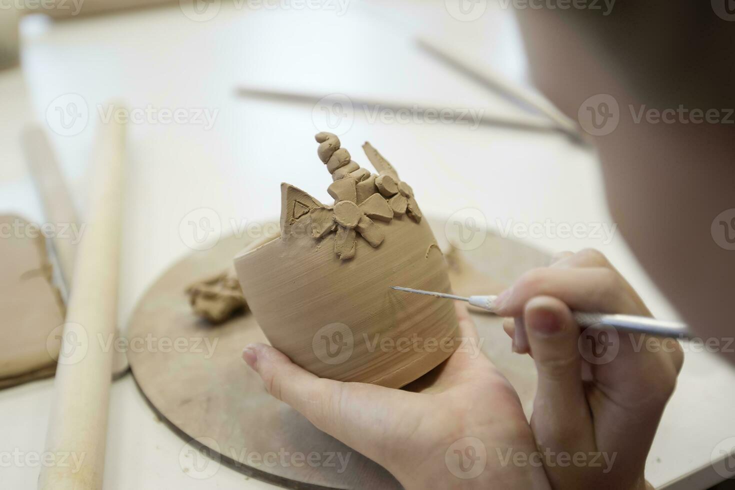 argilla modellismo officina. un' ragazza scolpisce un' tazza a partire dal argilla. foto